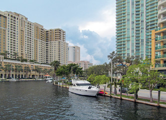 Fototapeta premium Fort Lauderdale, Florida, USA. Skyline view of downtown with canal, buildings, palm trees and boats on cloudy day. 