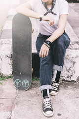 Asian Teen Girl With Skateboard style in outdoors skate park street with dark vintage tone style
