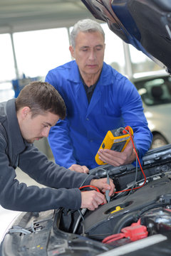 mechanic and apprentice working on car