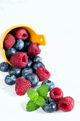 Berries of Blueberries and Raspberries, Poured from Basket, on White Background.