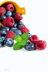 Berries of Blueberries and Raspberries, Poured from Basket, on White Background.