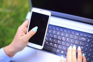 businesswoman with laptop and mobile phone in nature