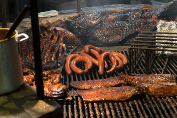 Texas style BBQ pit smoked meat ribs sausage over flame