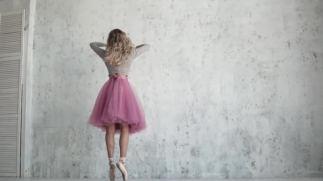 ballerina is spinning on toes in pointe shoes. beautiful young ballet dancer. pirouette in slow motion