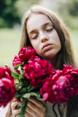 Naklejka premium Tender sensitive girl with blue eyes on a picnic with sweet creamy cheesecake with peonies