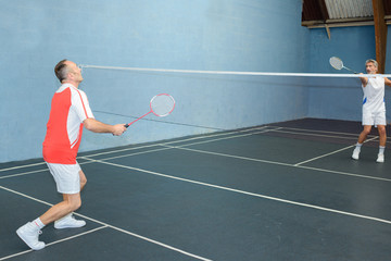 Two men playing badminton