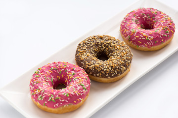 Разноцветные пончики в тарелке