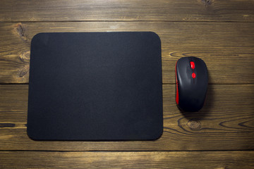 Computer mouse pad and mouse on a wooden background