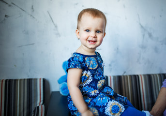 Fototapeta premium Year-old baby girl with blue eyes looking at camera. Happy little child 