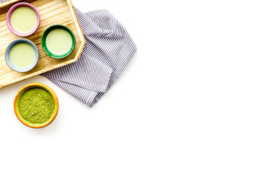 Japanise tea ceremony with matcha tea. Bowl with powder and cups with beverage on tablecloth on white background top view copy space