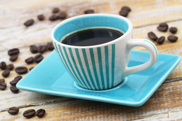 Espresso coffee in vintage blue and white striped cup on rustic wooden surface
