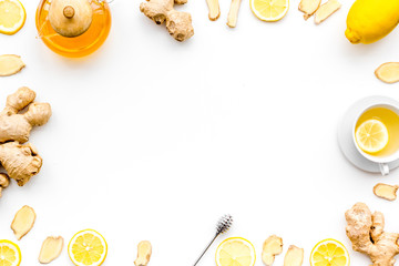 Warming tea with lemon and ginger. Cup, teapot, ginger root on white background top view copy space