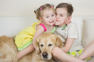 Cute Happy Kids Playing With Golden Retriever Dog On Bed