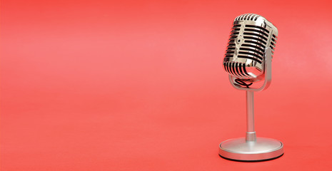 Retro vintage style metal microphone on red background banner