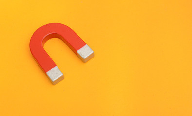 Red Magnet metal on yellow background education concept
