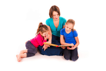 Mother reading a book to children isolated
