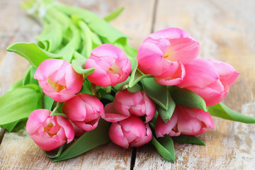 Bunch of pink Dutch tulips on rustic wooden surface with copy space
