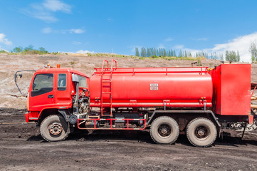 Fire engine or Fire truck in open-pit coal mine with blue sky background.