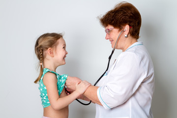 Portrait of female doctor listening to childs breathing using stethoscope