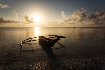 Traditional fishing boat in Zanzibar with storm clouds at sunrise