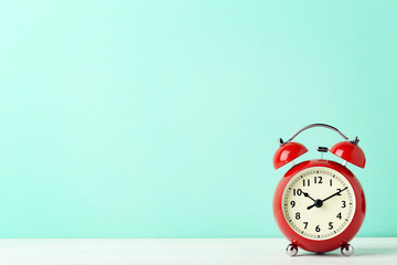Red alarm clock on mint background