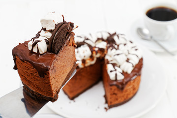 Piece of homemade cake with chocolate souffle decorated with marshmallow and cookies. Shallow focus.