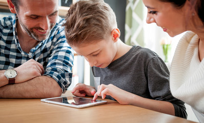 Obraz premium Happy family using tablet together at home