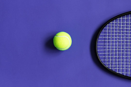Tennis ball and racket. Violet background. Concept sport. Copy space