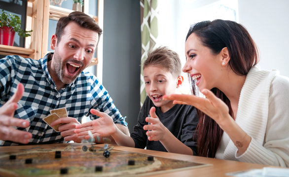 Happy family playing board game at home