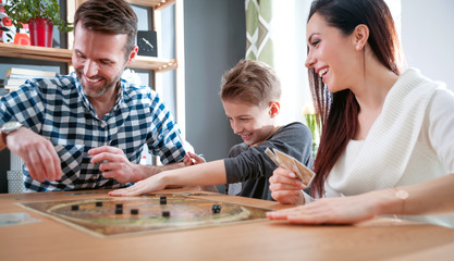 Happy family playing board game at home