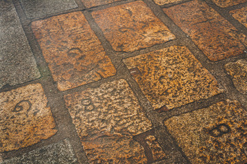 Stone floor with carved numbers, signature of the stone mason who laid that piece, in abbey of Le Mont Saint-Michel tidal island in Normandy, France