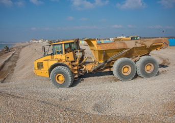 Obraz premium Construction Site - Engineering - Sea Defence. Large plant machinery being use to build the beach sea defence at Seaford, East Sussex, UK