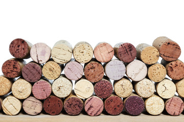 Multicolored bright corks from wine bottles on a wooden table isolated on a white background. Rows of corks with stain of red wine.