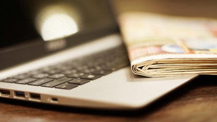 Newspaper on laptop. Computer and daily papers with news. Concept for communication and...