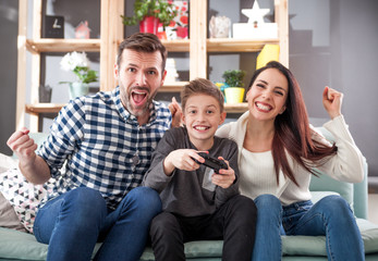 Excited family playing video game at home