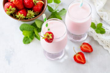 Fresh strawberry smoothie and fresh strawberries on a gray stone or slate background. Vegan dish. Proper nutrition. Healthy lifestyle. Copy space.