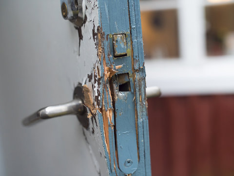 Broken door in blue and white colors after a burglery