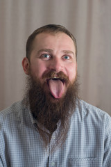 Portrait of a man with a long beard that shows the tongue