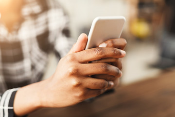 African-american woman holding smartphone, closeup