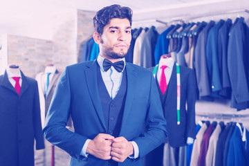 Male is demonstrating his choice of suit with jacket