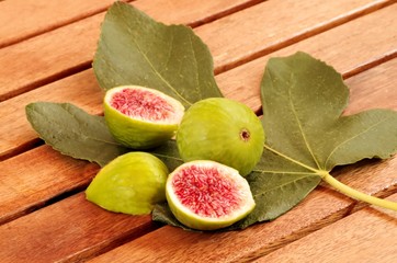 Frische rote Feigen mit Feigenblatt auf Holztisch