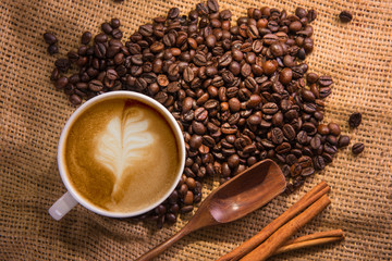 white coffee cup and roasted coffee beans around