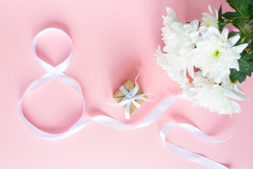 Fototapeta na wymiar White gift celebration ribbon in 8 digit shape over pink background