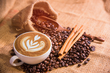 white coffee cup and roasted coffee beans around