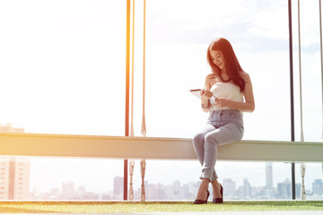 young asian woman using tablet with city background