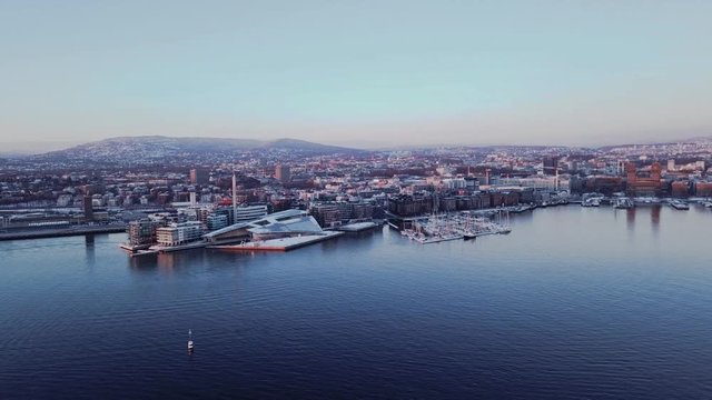 Aerial clockwise tripod shot at sunset of Aker Brygge and City Hall in Oslo, Norway seen from fjord