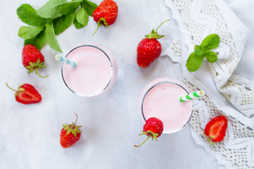 Fresh strawberry smoothie and fresh strawberries on a gray stone or slate background. Vegan dish. Proper nutrition. Healthy lifestyle. Top view with copy space.