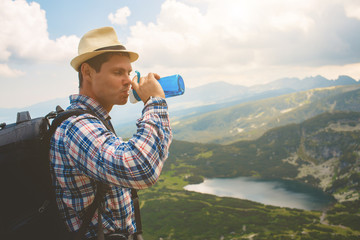 Traveler drinks water in the mountains
