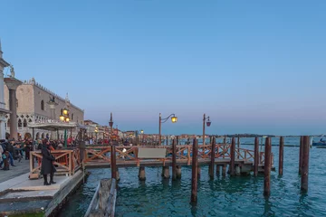 Fotobehang VENICE, ITALY - FEBRUARY 10 2018: Evening view of the pier in front of Hotel Cipriani near San Marco square © Gianluca