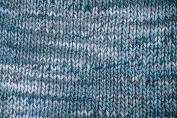 Wool scarf texture close up. Knitted jersey background with a relief pattern. Braids in machine knitting